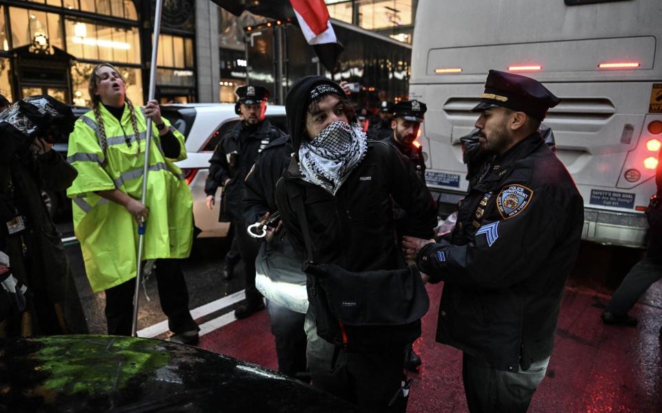 Police detain some of the protesters as hundreds of people gather in front of Radio City Music Hall to stage a demonstration protesting US President Joe Biden's support for Israel in New York, United States