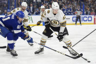 Boston Bruins left wing Danton Heinen (43) tries to work around Tampa Bay Lightning defenseman Erik Cernak (81) during the first period of an NHL hockey game Wednesday, March 27, 2024, in Tampa, Fla. (AP Photo/Chris O'Meara)