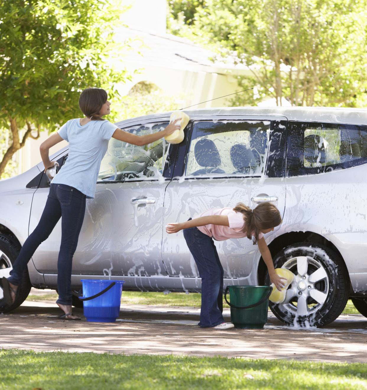 Two Girls Outside Washing Car Together.