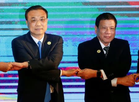 Chinese Premier Li Keqiang and Philippines President Rodrigo Duterte pose for photo during the ASEAN Plus Three Summit in Vientiane, Laos September 7, 2016. REUTERS/Soe Zeya Tun/Files