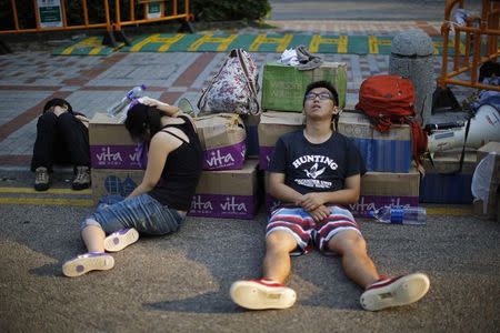 Protesters sleep as they block a street outside government headquarters in Hong Kong September 30, 2014. REUTERS/Carlos Barria