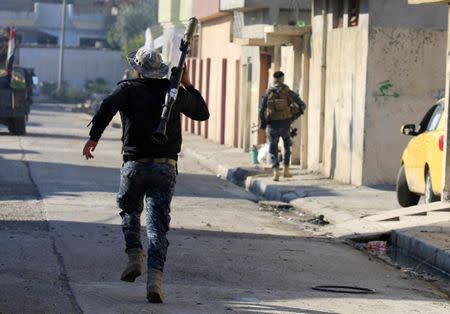 Iraqi rapid response forces run across a street during battle with Islamic State militants in Wahda district of eastern Mosul, Iraq, January 6, 2017. REUTERS/Alaa Al-Marjani