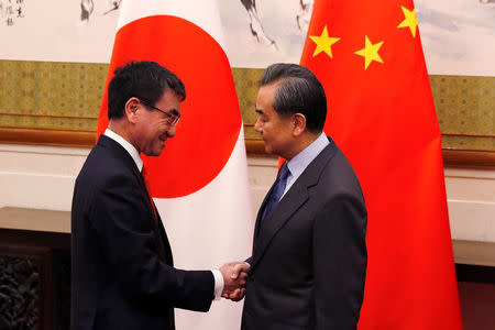 Japanese Foreign Minister Taro Kono, left, shakes hands with his Chinese counterpart Wang Yi before their meeting at the Diaoyutai State Guesthouse in Beijing, China Jan. 28, 2018. REUTERS/Andy Wong/Pool