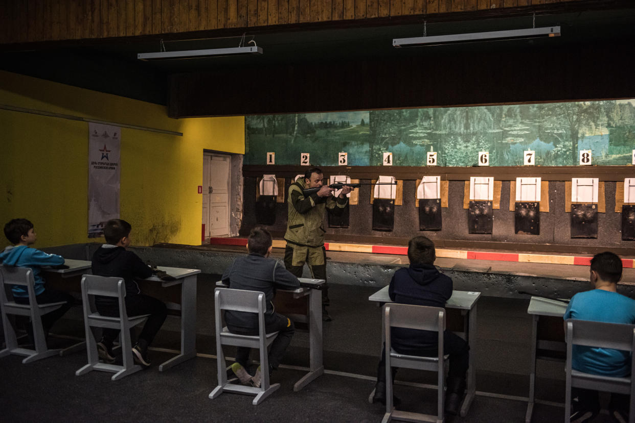 Un instructor le muestra a un grupo de niños cómo usar rifles de aire comprimido en el centro de capacitación de prerreclutamiento juvenil en Noguinsk, cerca de Moscú, el 15 de diciembre de 2021. (Sergey Ponomarev/The New York Times)
