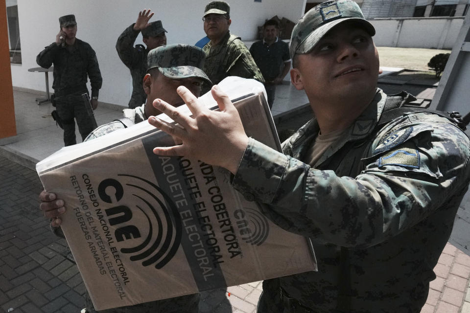 Soldiers unload election materials at a polling station, in Quito, Ecuador, Saturday, Aug. 19, 2023. Ecuador is holding a special election on Sunday to pick a new president, with police and soldiers on guard against unprecedented violence including the assassination of a candidate this month. (AP Photo/Dolores Ochoa)