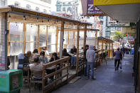 People eat lunch in Chinatown parklets along Jackson Street in San Francisco, Monday, May 23, 2022. Chinatowns and other Asian American enclaves across the U.S. are using art and culture to show they are safe and vibrant hubs nearly three years after the start of the pandemic. From an inaugural arts festival in San Francisco to night markets in New York City, the rise in anti-Asian hate crimes has re-energized these communities and drawn allies and younger generations of Asian and Pacific Islander Americans. (AP Photo/Eric Risberg)