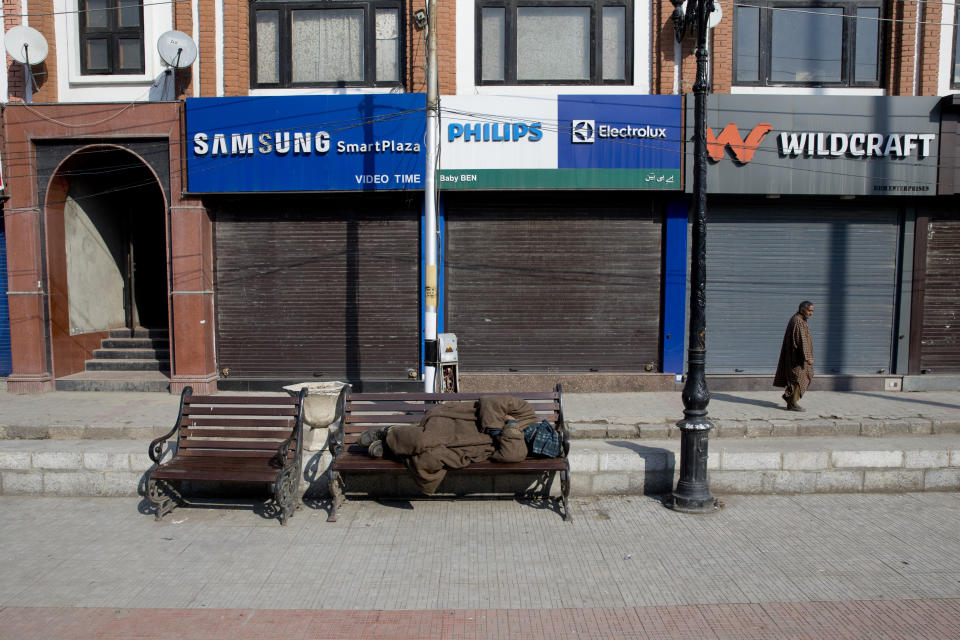 A Kashmiri man sleeps on a bench outside a closed market during a strike in Srinagar, Indian controlled Kashmir, Thursday, Feb. 28, 2019. As tensions escalate between India and Pakistan, shops and business remained closed for the second consecutive day in Indian portion of Kashmir following a strike call by separatist leaders to protest Tuesday's raids on key separatist leaders by Indian intelligence officers. (AP Photo/ Dar Yasin)