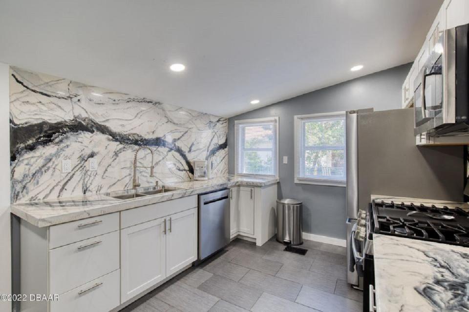 This completely remodeled kitchen features gorgeous new cabinets, stainless-steel appliances, a deep double sink and jaw-dropping marble countertops.