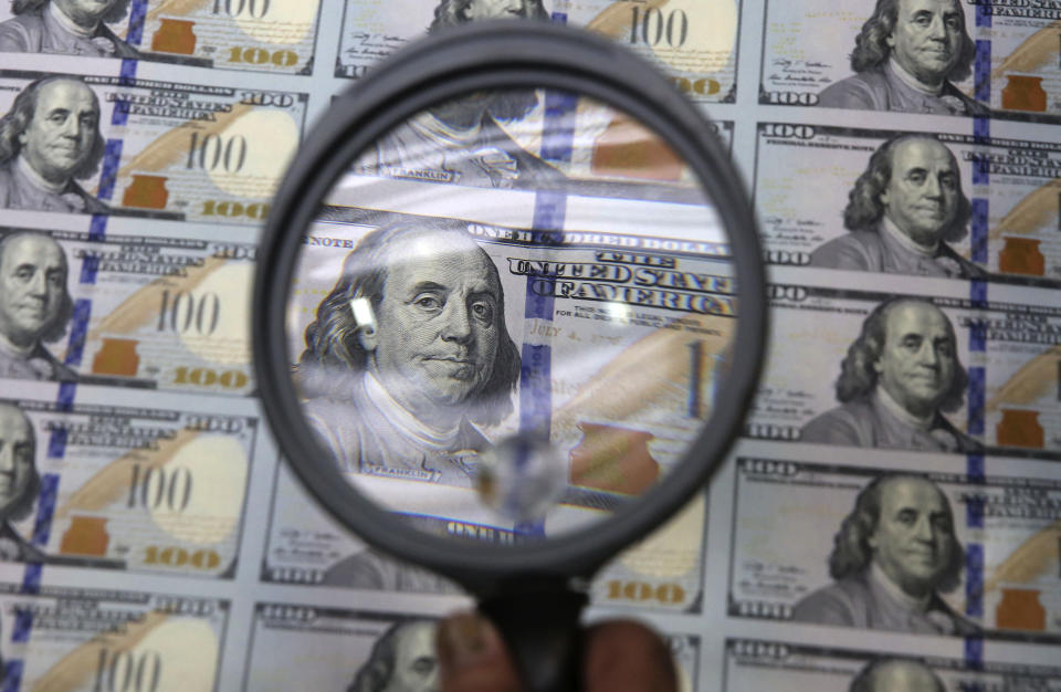 FILE - A sheet of uncut $100 bills is inspected during the printing process at the Bureau of Engraving and Printing Western Currency Facility in Fort Worth, Texas, on Sept. 24, 2013. An Associated Press analysis published on Monday, June 12, 2023, found that fraudsters potentially stole more than $280 billion in COVID-19 relief funding; another $123 billion was wasted or misspent. Combined, the loss represents a jarring 10 percent of the total $4.2 trillion the U.S. government has so far disbursed in COVID-relief aid. (AP Photo/LM Otero, File)