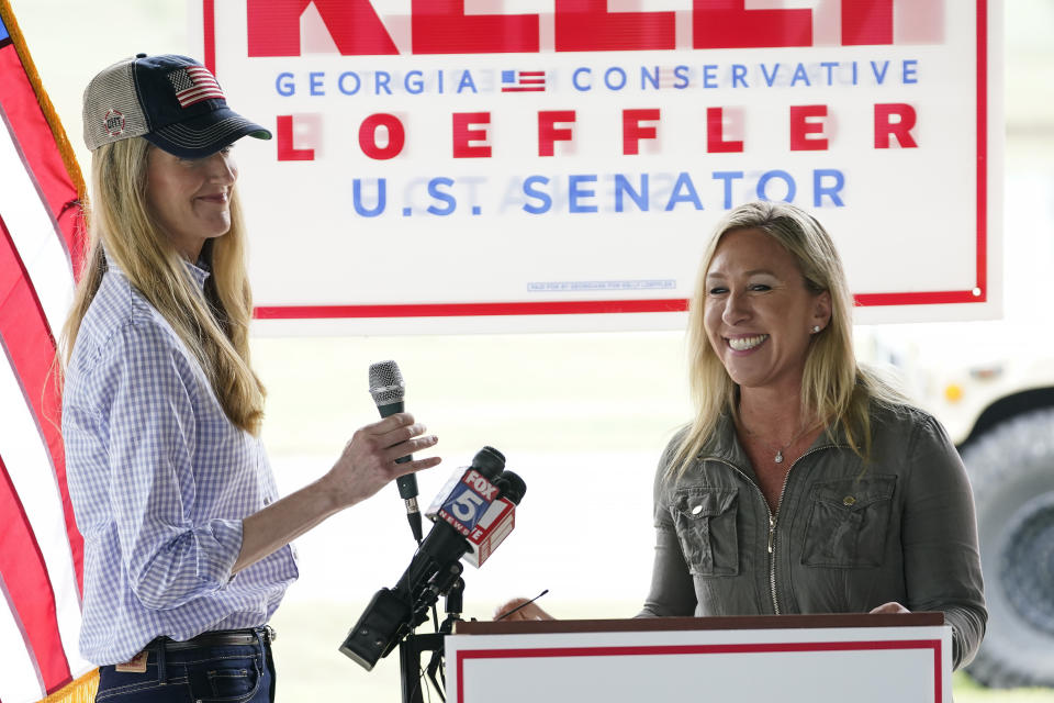 Republican congressional candidate Marjorie Taylor Greene, right, introduces Sen. Kelly Loeffler, R-Ga., left, during a news conference on Thursday, Oct. 15, 2020, in Dallas, Ga. (AP Photo/Brynn Anderson)