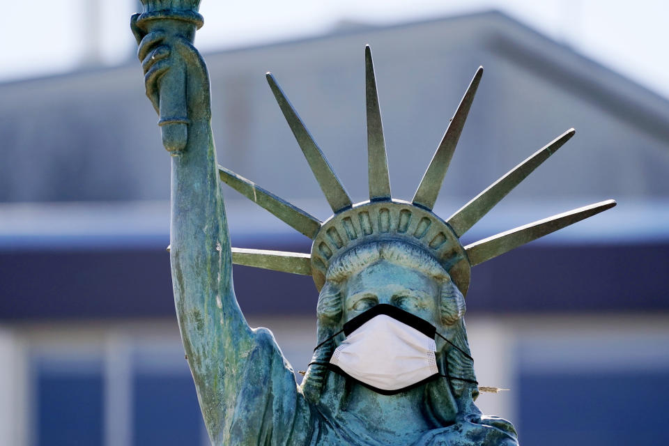 The face on a replica of the Statue of Liberty covers with a protective face mask against the coronavirus Wednesday, Aug. 26, 2020, in Seattle. The 1/18th scale replica on Seattle's Alki Beach was erected in 1952 and recast in 2006. (AP Photo/Elaine Thompson)