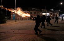 Riot police fire tear gas as demonstrators protest at the National University as a national strike continues in Bogota