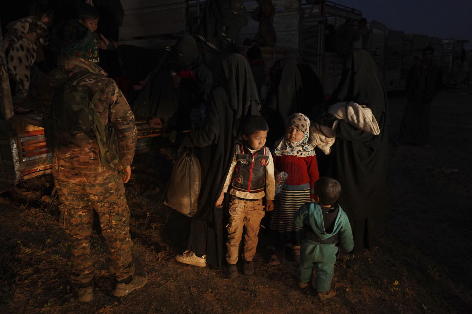 U.S.-backed Syrian Democratic Forces (SDF) move women and children into a truck after being evacuated out of the last territory held by Islamic State militants, outside Baghouz, Syria, Monday, March 4, 2019. Hundreds of people including IS fighters evacuated their last foothold in eastern Syria hours after U.S.-backed Syrian fighters said they were forced to slow their advance because the extremists are using civilians as human shields.(AP Photo/Andrea Rosa)