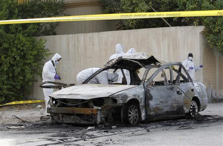 Forensic experts investigate at the scene of a car explosion in the village of al-Maqshaa, west of Manama April 19, 2014. REUTERS/Hamad I Mohammed