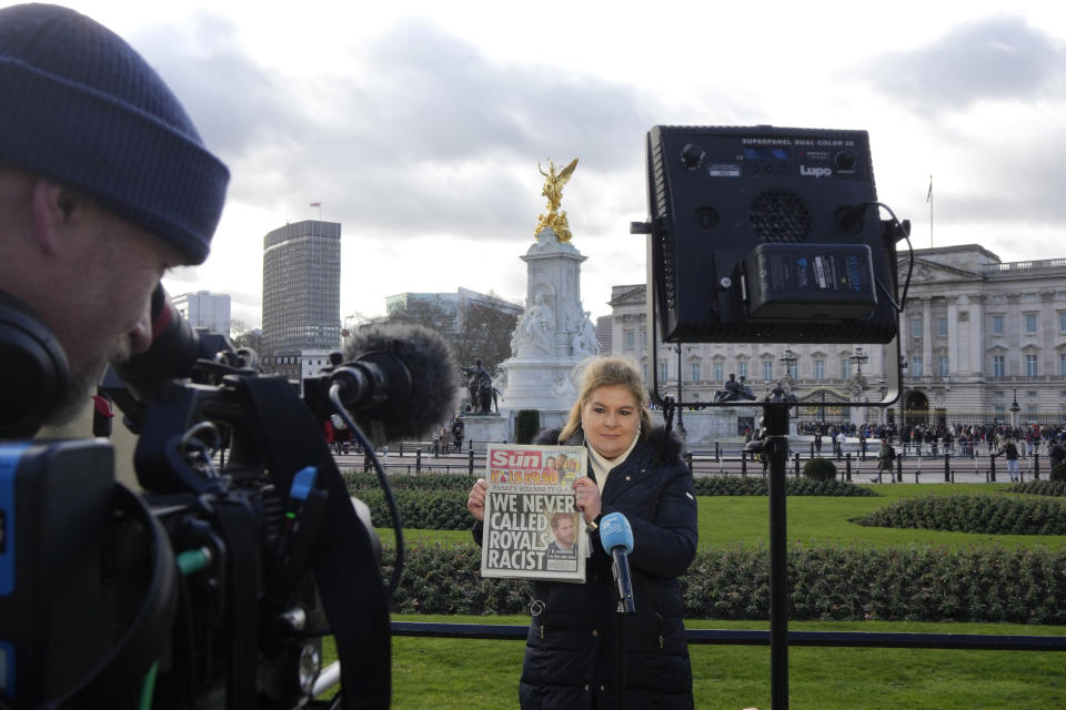 A journalist holds up a copy of a UK newspaper as she reports outside Buckingham Palace in London, Monday, Jan. 9, 2023. Prince Harry has defended his memoir that lays bare rifts inside Britain's royal family. He says in TV interviews broadcast Sunday that he wanted to "own my story" after 38 years of "spin and distortion" by others. Harry's soul-baring new memoir, "Spare," has generated incendiary headlines even before its release. (AP Photo/Kirsty Wigglesworth)