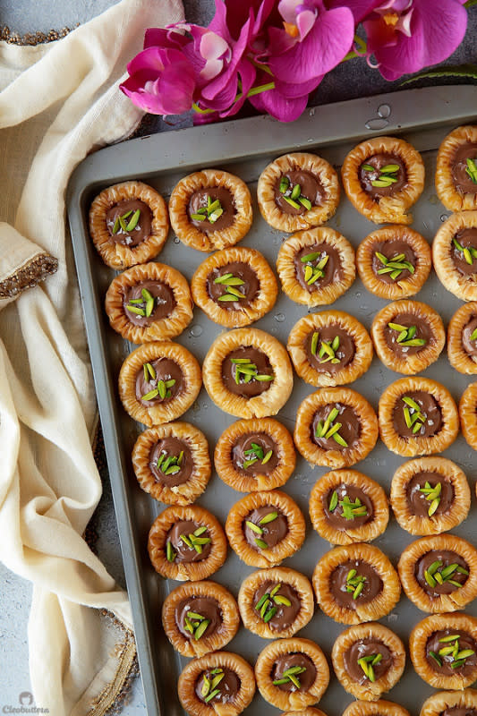 <p>Delicately crisp phyllo rings with a creamy chocolate center, a sprinkling of sea salt and crunchy pistachios!</p><p><strong>Get the recipe: <a href="https://cleobuttera.com/middle-eastern/chocolate-baklava-bracelets-asawer-el-sit/" rel="nofollow noopener" target="_blank" data-ylk="slk:Chocolate Baklava Bracelets (Asawer El Sit);elm:context_link;itc:0;sec:content-canvas" class="link ">Chocolate Baklava Bracelets (Asawer El Sit)</a></strong></p>