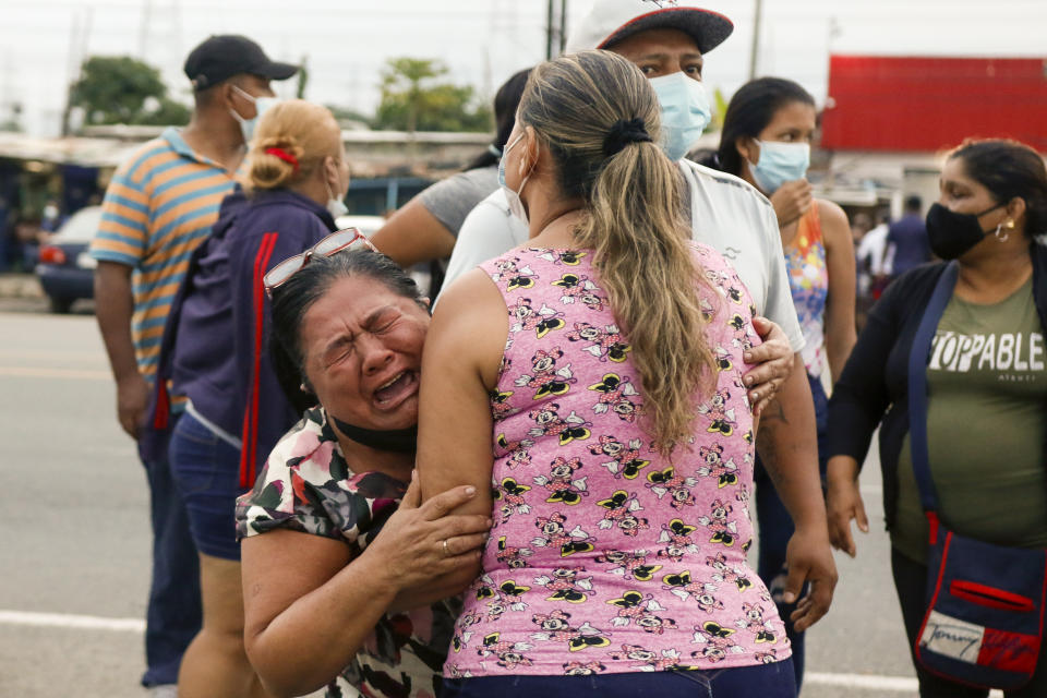 Relatives of inmates cry outside the Centro de Privación de Libertad Zona 8 prison where riots broke out in Guayaquil, Ecuador, Tuesday, Feb. 23, 2021. Deadly riots broke out in prisons in three cities across the country due to fights between rival gangs, according to police. (AP Photo/Angel Dejesus)