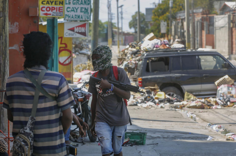 Armed members of the G9 and Family gang stand guard at their roadblock in the Delmas 6 neighborhood of Port-au-Prince, Haiti, Monday, March 11, 2024. (AP Photo/Odelyn Joseph)