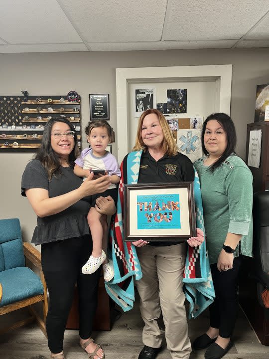 Howe family presents Arkansas City Fire/EMS Director Jeri Wheatley with Ponca tribal blanket for saving 2-year-old Luna (courtesy Arkansas City)