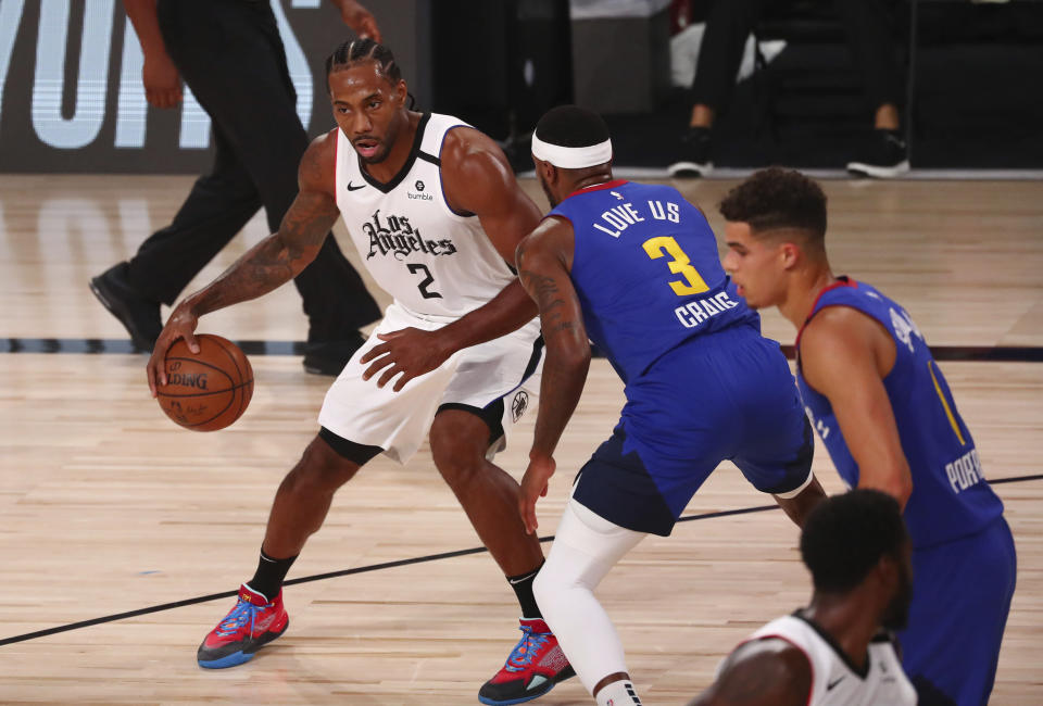 Los Angeles Clippers forward Kawhi Leonard (2) drives to the basket against Denver Nuggets forward Torrey Craig (3) in the first half of an NBA basketball game Wednesday, Aug. 12, 2020, in Lake Buena Vista, Fla. (Kim Klement/Pool Photo via AP)
