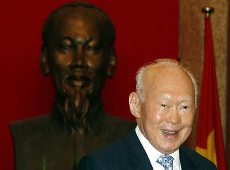 Singapore's former Prime Minister Lee Kuan Yew poses for a photo in front of statue of Vietnamese late revolutionary leader Ho Chi Minh before a meeting with Vietnam's former President Nguyen Minh Triet at the Presidential Palace in Hanoi April 16, 2009. REUTERS/Kham/Files