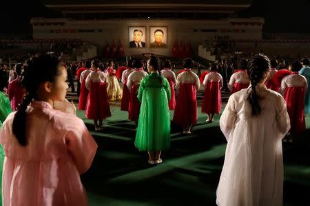 Portraits of North Korea founder Kim Il Sung and late leader Kim Jong Il glow as people take part in a mass dance event marking the 105th birth anniversary of Kim Il Sung in Pyongyang, North Korea April 15, 2017. REUTERS/Damir Sagolj/Files