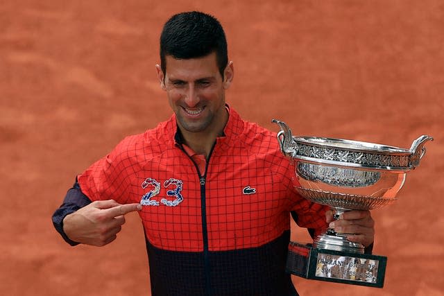 Novak Djokovic points to the number 23 on his jacket as he celebrates his French Open