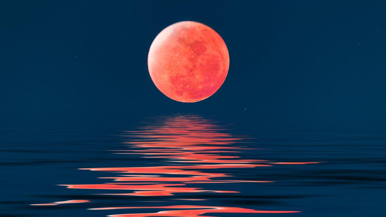 Super blue blood full moon over cold night water.