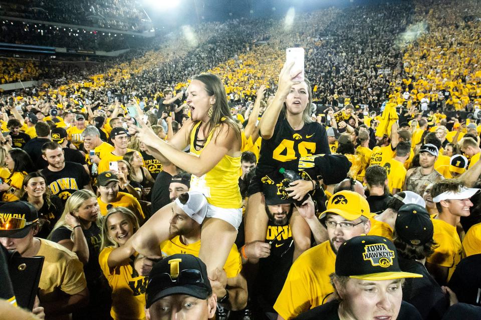 Iowa Hawkeyes fans celebrate while storming the field after a NCAA Big Ten Conference football game against Penn State, Saturday, Oct. 9, 2021, at Kinnick Stadium in Iowa City, Iowa. Iowa beat Penn State, 23-20.