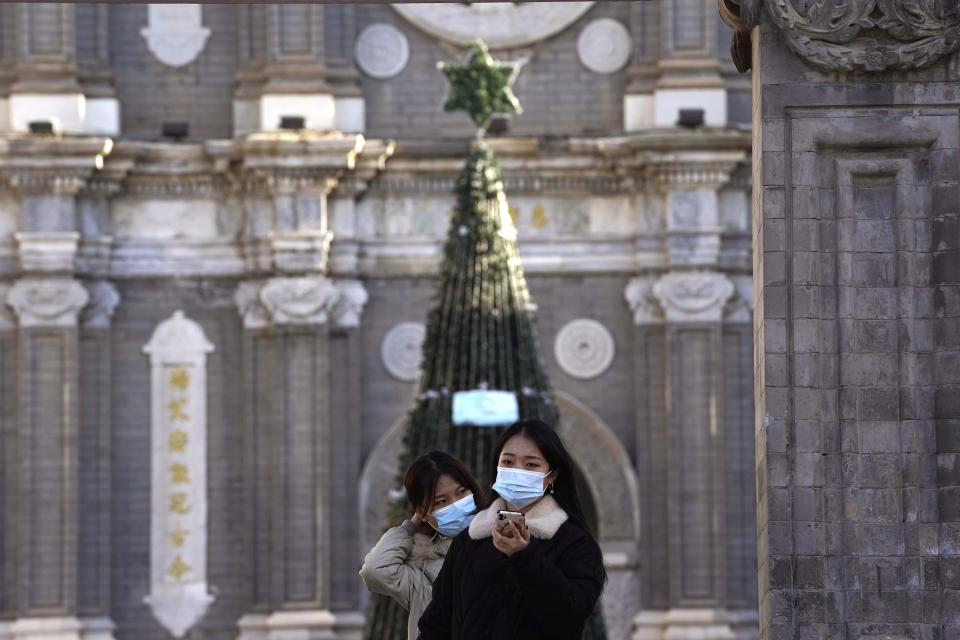 Visitors pose for a selfie outside the Wangfujing Church in Beijing on Friday, Dec. 25, 2020. Official churches in the Chinese capital abruptly cancelled mass on Christmas day in a last-minute move owing to the pandemic. The capital city is on high alert after new confirmed COVID-19 cases were reported last week and new asymptomatic cases reported Christmas day. (AP Photo/Ng Han Guan)