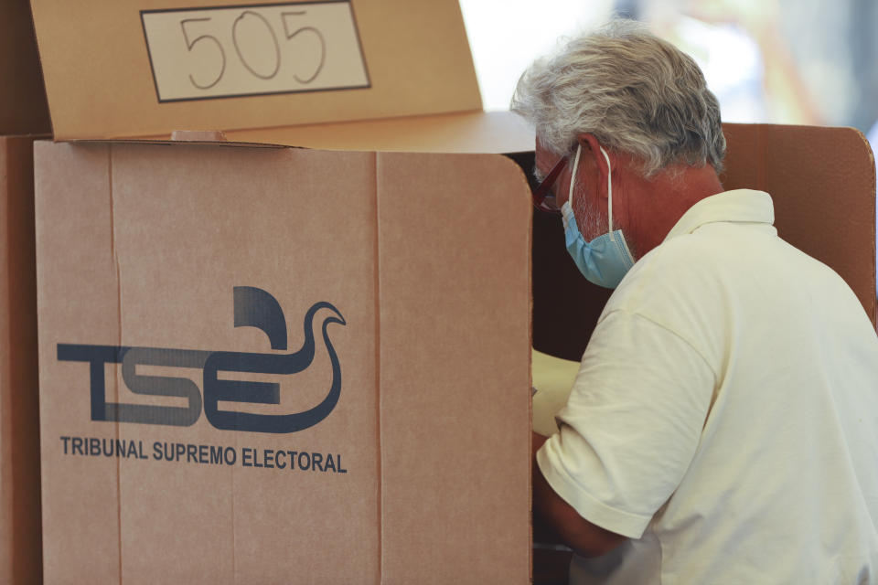 A voter prepares his ballots for local and legislative elections behind a privacy screen at a polling place in the Zona Rosa district of San Salvador, El Salvador, Sunday, Feb. 28, 2021. Sunday's elections in El Salvador are seen as a referendum on whether to break the congressional deadlock that has tied the hands of upstart populist President Nayib Bukele. (AP Photo/Salvador Melendez)