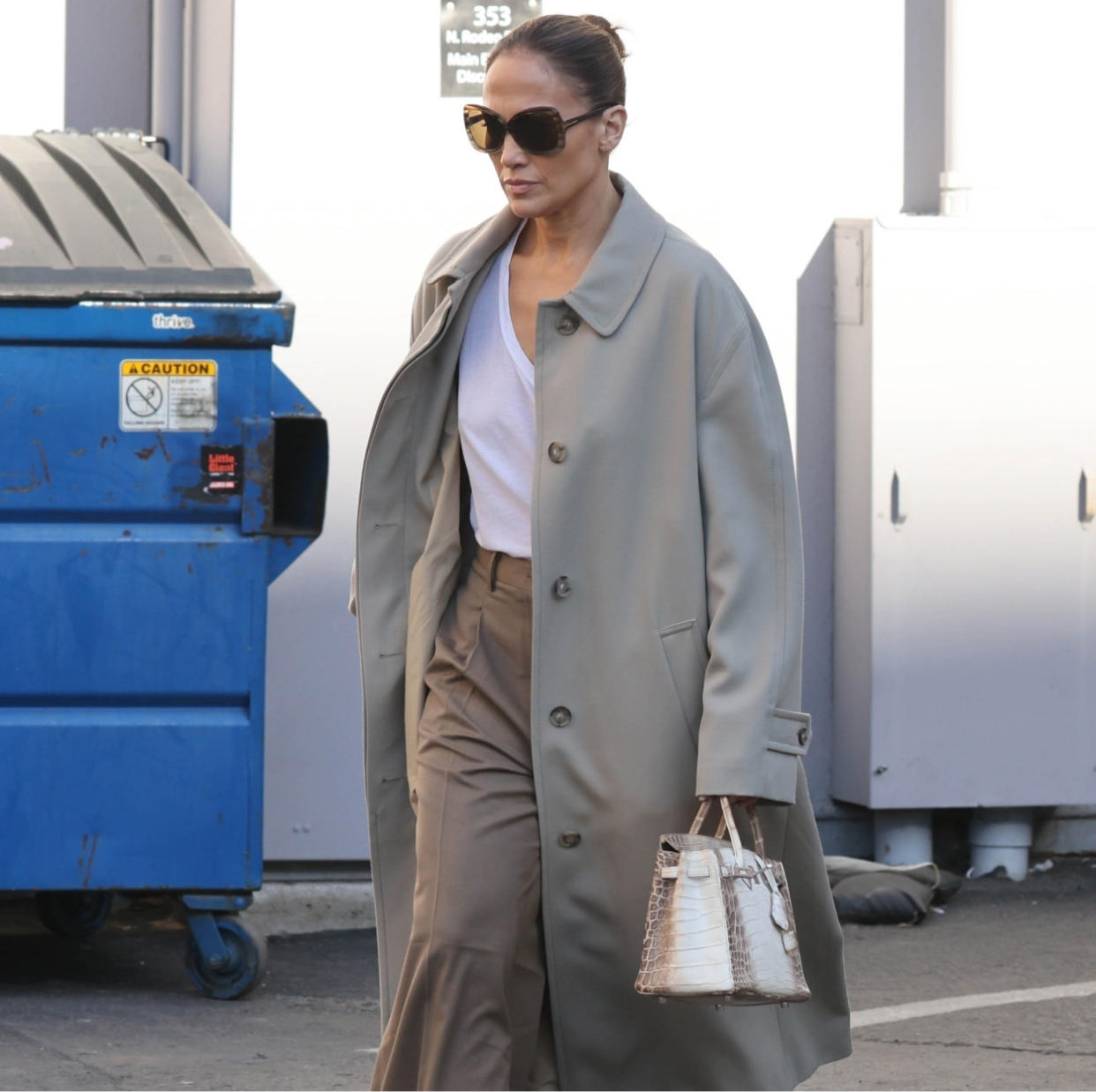  Jennifer Lopez in a tan trench coat and white tee. 