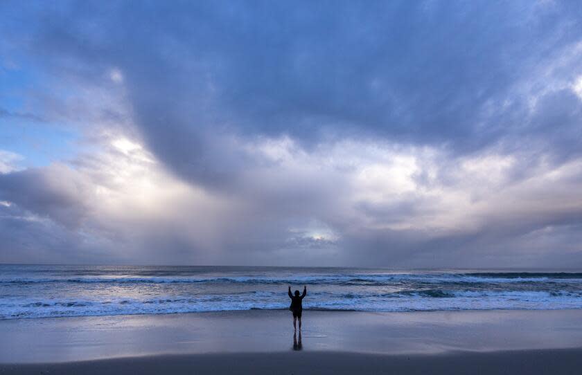 Santa Monica, CA - March 31: A man exercises in the surf as a late season storm moves out of Southern California on Sunday, March 31, 2024 in Santa Monica, CA. (Brian van der Brug / Los Angeles Times)