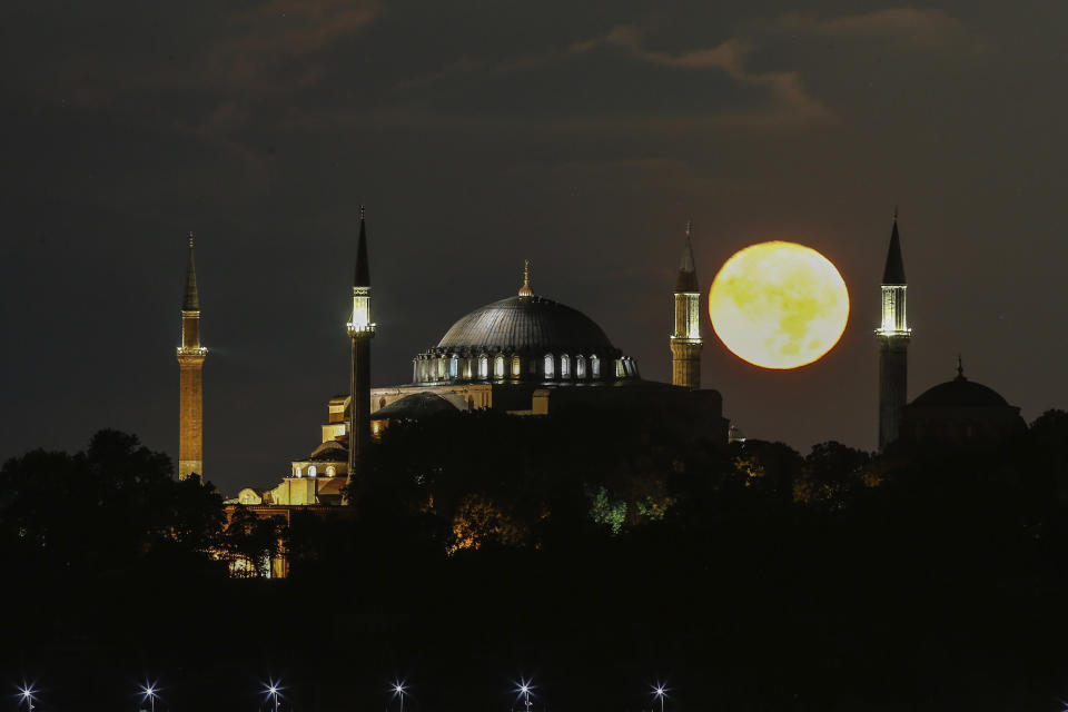 The full moon rises behind the Byzantine-era Hagia Sophia, in the historic Sultanahmet district of Istanbul, early Tuesday, Sept. 1, 2020. Worshipers held the first Muslim prayers in 86 years inside the Istanbul landmark that served as one of Christendom's most significant cathedrals, a mosque and a museum before its conversion back into a Muslim place of worship on July 24, 2020. The conversion of the edifice, has led to an international outcry. (AP Photo/Emrah Gurel)