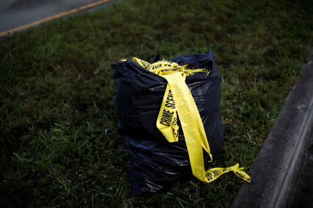 A garbage bag full of crime scene tape is seen close to the campus of Marjory Stoneman Douglas High School, after the police security perimeter was removed, following a mass shooting in Parkland, Florida, U.S., February 18, 2018. REUTERS/Carlos Garcia Rawlins/Files