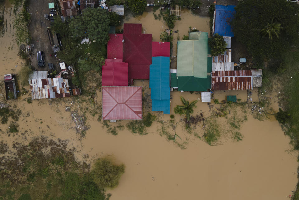 Floodwaters surround a residential area from to Typhoon Noru in San Miguel town, Bulacan province, Philippines, Monday, Sept. 26, 2022. Typhoon Noru blew out of the northern Philippines on Monday, leaving some people dead, causing floods and power outages and forcing officials to suspend classes and government work in the capital and outlying provinces. (AP Photo/Aaron Favila)