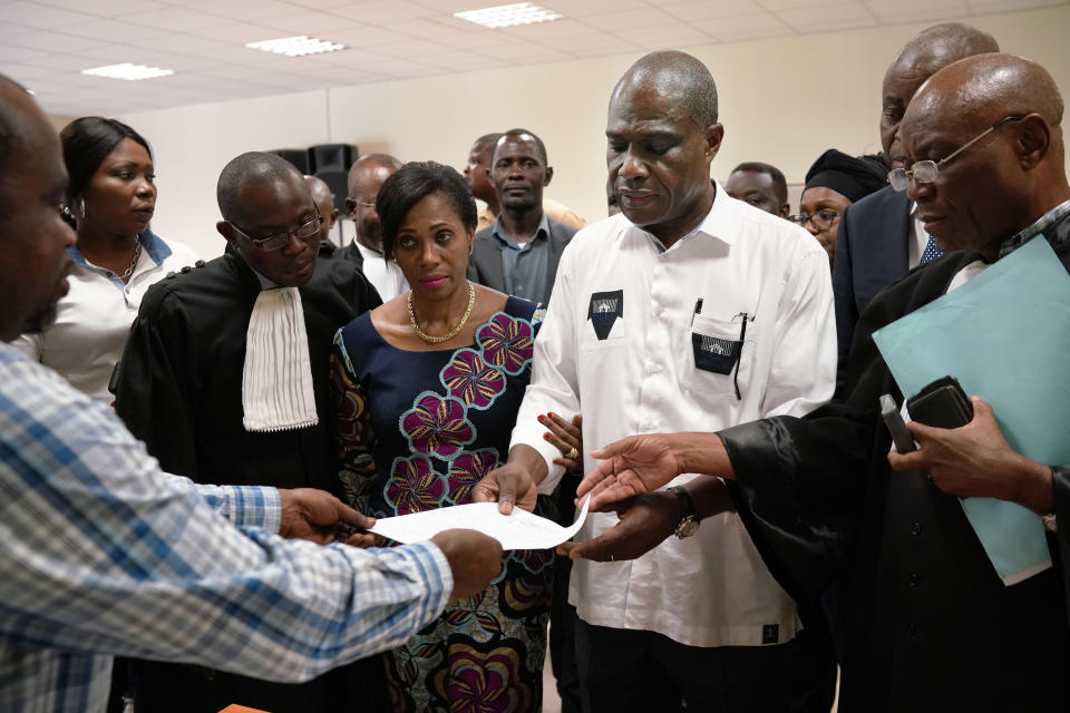 Accompanied by his wife and his lawyers, Congo opposition candidate Martin Fayulu receives the receipt after petitioning the constitutional court following his loss in the presidential elections in Kinshasa, Congo, Saturday Jan. 12, 2019. The ruling coalition of Congo's outgoing President Joseph Kabila has won a large majority of national assembly seats, the electoral commission announced Saturday, while the presidential election runner-up was poised to file a court challenge alleging fraud. (AP Photo/Jerome Delay)