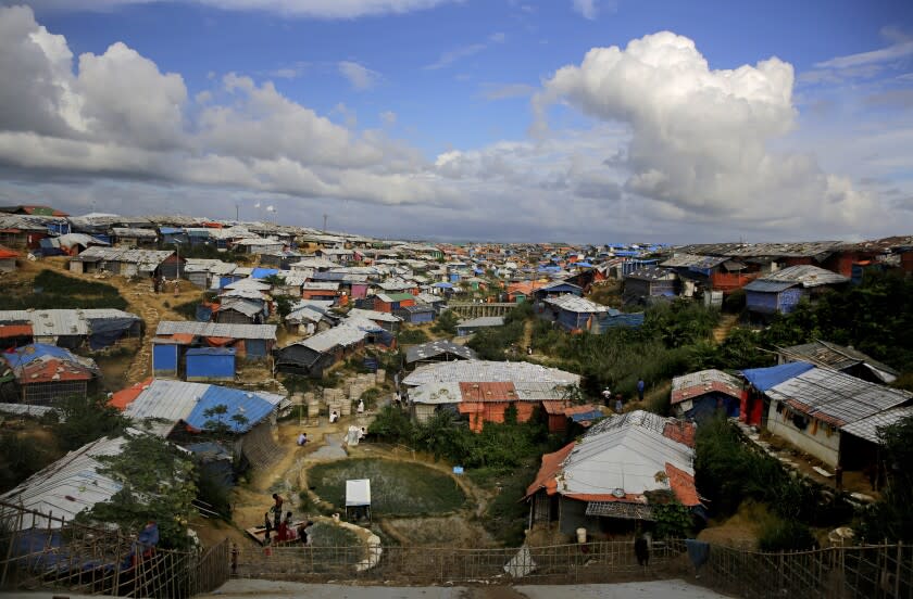 FILE - Rohingya refugees bathe at a hand water pump at Kutupalong refugee camp, where they have been living amid uncertainty over their future after they fled Myanmar to escape violence a year ago, in Bangladesh, Sunday, Aug. 26, 2018. The number of people forced to flee conflict, violence, human rights violations and persecution has crossed the milestone of 100 million for the first time on record, propelled by the war in Ukraine and other deadly conflicts, The U.N. refugee agency said Monday, May 23, 2022. (AP Photo/Altaf Qadri, File)