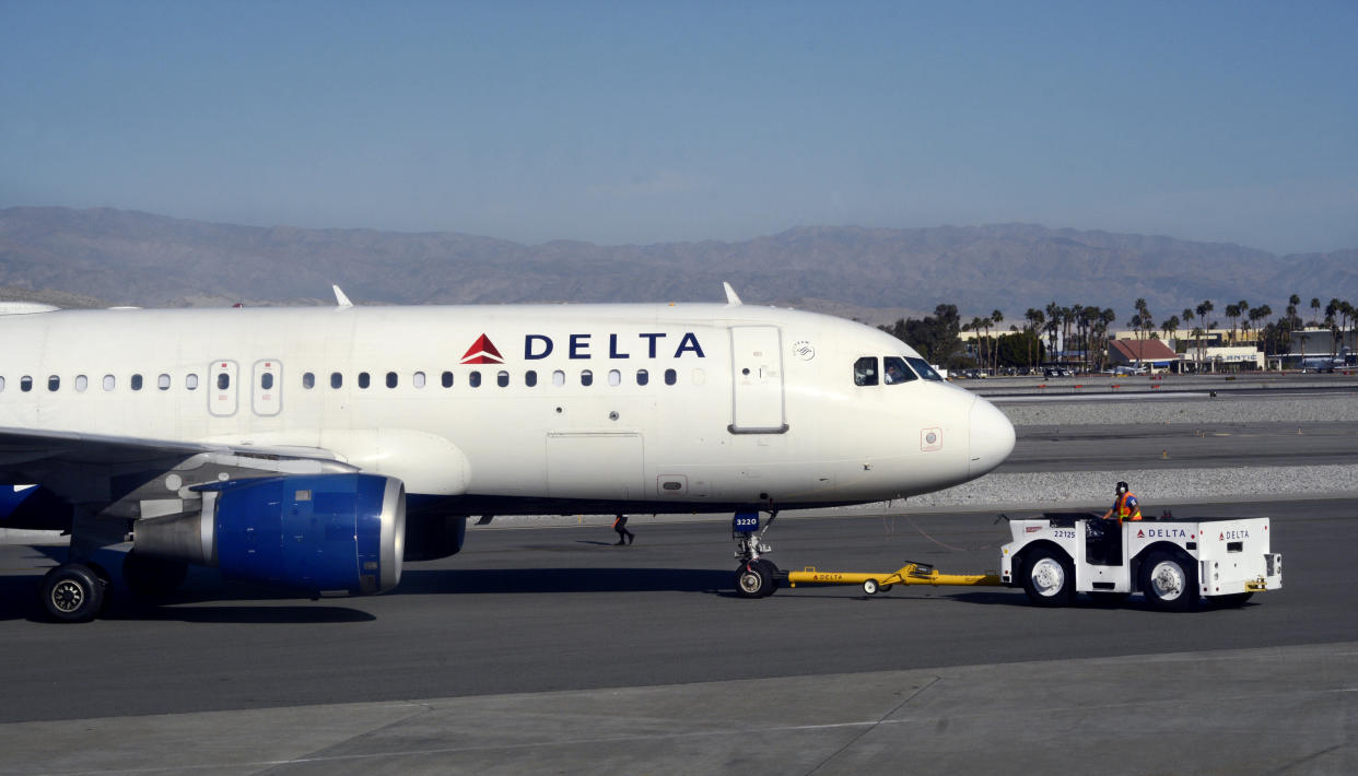 PALM SPRINGS, CALIFORNIA - FEBRUARY 25, 2019:  A Delta Air Llnes ground crew member pushes a passenger aircraft from the gate at Palm Springs International Airport in Palm Springs, California. (Photo by Robert Alexander/Getty Images)