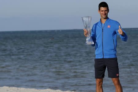 Apr 5, 2015; Key Biscayne, FL, USA; Novak Djokovic poses for a champion's portrait with the Butch Buchholz Trophy after his match against Any Murray (not pictured) in the men's singles final on day fourteen of the Miami Open at Crandon Park Tennis Center. Geoff Burke-USA TODAY Sports