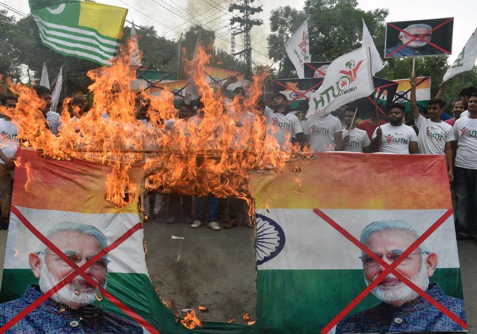 Activists of the 'Youth Forum for Kashmir' group shout slogans as they burn a picture of Indian Prime Minister Narendra Modi and the Indian flag during a protest in Lahore, Pakistan, Aug. 15, 2019. / Credit: Getty