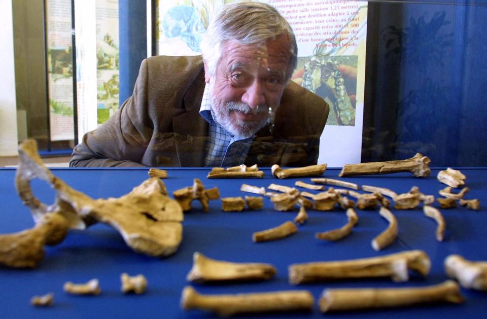 French anthropologist Yves Coppens poses by bones from "Lucy" on July 10, 2004.