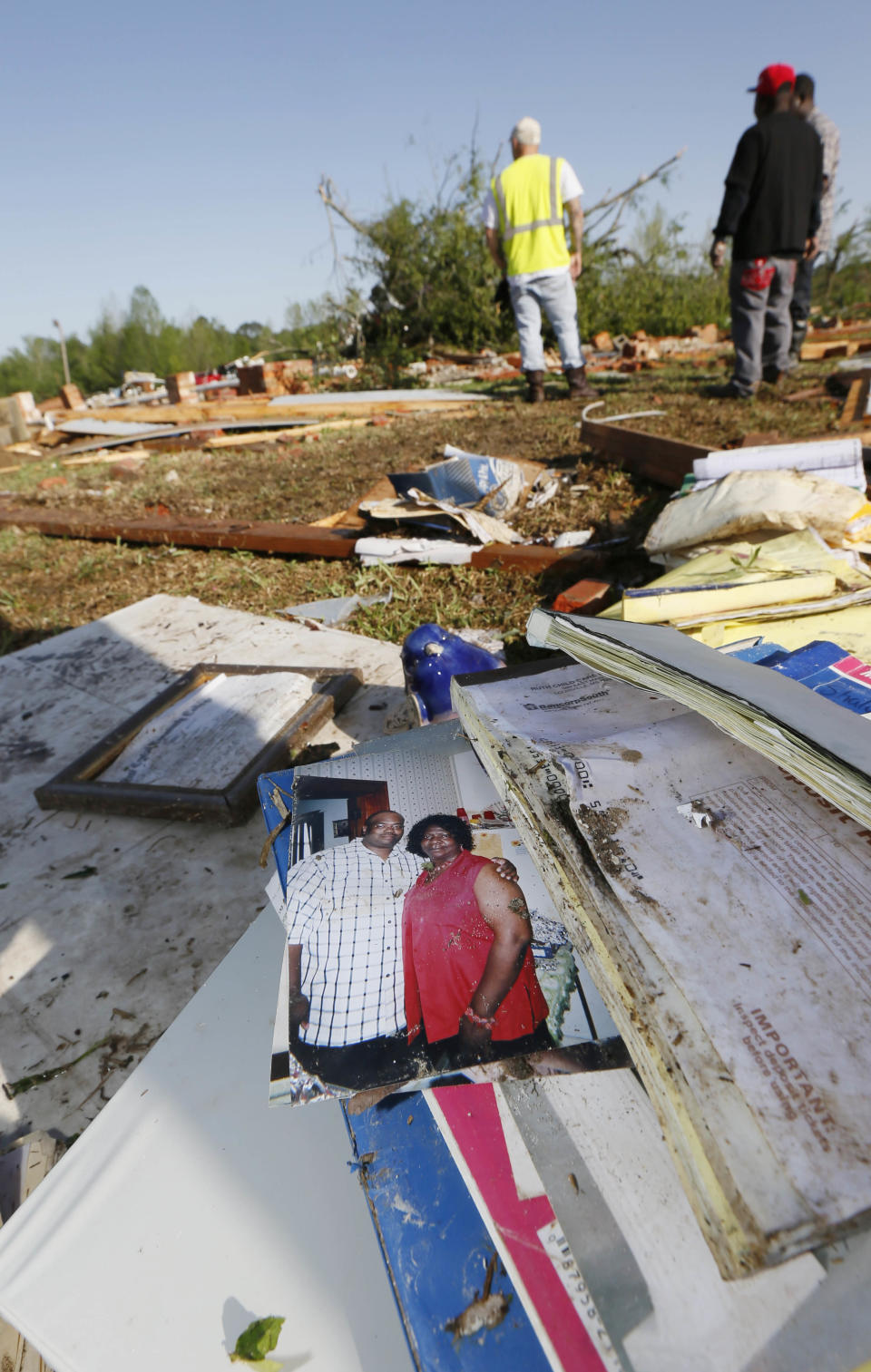 An photograph of Ruth Bennett, right, a child care owner, who was killed at her facility by Monday's tornado, dries outside the remains of the building in Louisville, Miss.,Tuesday, April 29, 2014. Bennett died while clutching a child as a tornado wiped her business off its foundation, strewing it into the backyard of a neighboring home. (AP Photo/Rogelio V. Solis)