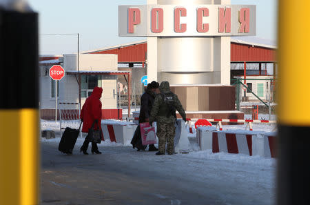 A member of the Ukrainian State Border Guard Service accompanies women who were denied entry to the country at the Goptovka crossing point on the border between Russia and Ukraine in Kharkiv Region, Ukraine November 30, 2018. REUTERS/Vyacheslav Madiyevsky