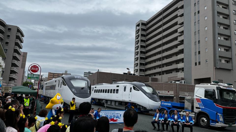 日立笠戶製作所把EMU3000型列車安置在兩台拖車上，白天在日本街道遊行，馬路兩旁的人行道擠滿了人造成轟動。台鐵提供