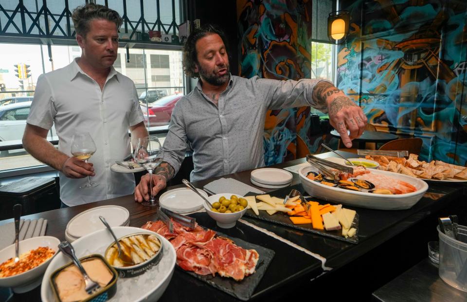 1033 co-owner Rob Levin shows Chris Corley Prince Edward Island mussels among a spread of other offerings from the restaurant and bar during a private happy hour on May 23, 2023.