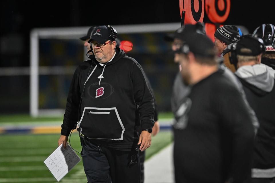 Badger head coach Matt Hensler walks the sideline during his team's WIAA Division 2 Level 3 playoff football game Friday night against Kettle Moraine.