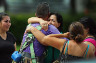 Family members hug a construction worker who was working on a four-story parking garage that was under construction and collapsed at the Miami Dade College?s West Campus on October 10, 2012 in Doral, Florida. Early reports indicate that one person was killed, at least seven people injured and an unknown number of people may be buried in the rubble. (Photo by Joe Raedle/Getty Images)