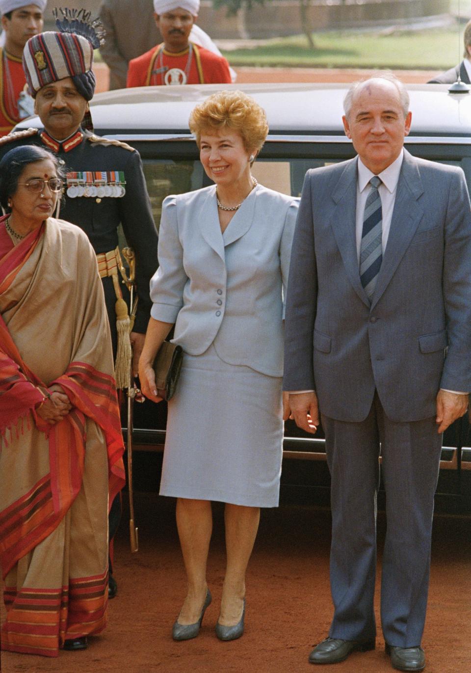 FILE - Mrs. Raisa Gorbachev flanked by her husband on the right, and Mrs. R. Venkatarman, wife of India President, on the left, beams with a fashionable dress as they gathered at the welcome ceremony, Friday, Nov. 18, 1988 in New Delhi, India. Gorbachevs arrive for a three-day official visit. When Mikhail Gorbachev is buried Saturday at Moscow's Novodevichy Cemetery, he will once again be next to his wife, Raisa, with whom he shared the world stage in a visibly close and loving marriage that was unprecedented for a Soviet leader. Gorbachev's very public devotion to his family broke the stuffy mold of previous Soviet leaders, just as his openness to political reform did. (AP Photo/Liu Heung Shing, File)