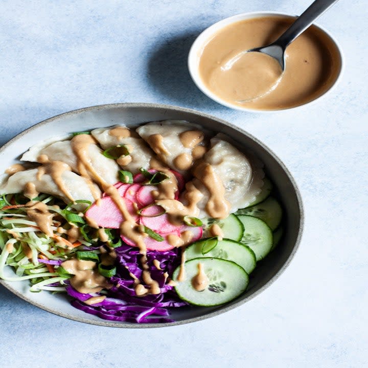 Bowl of cucumbers, radish, sprouts, pickled daikon, and dumplings